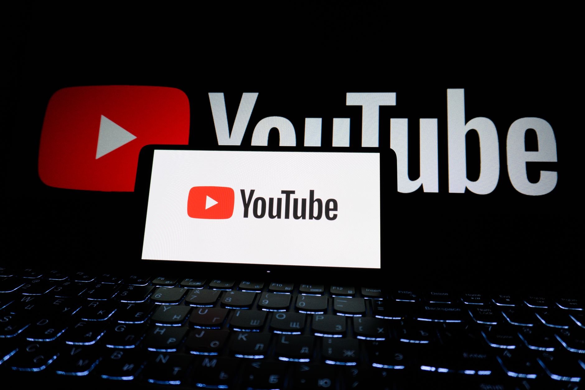 YouTube logo displayed on laptop screen in dark setting