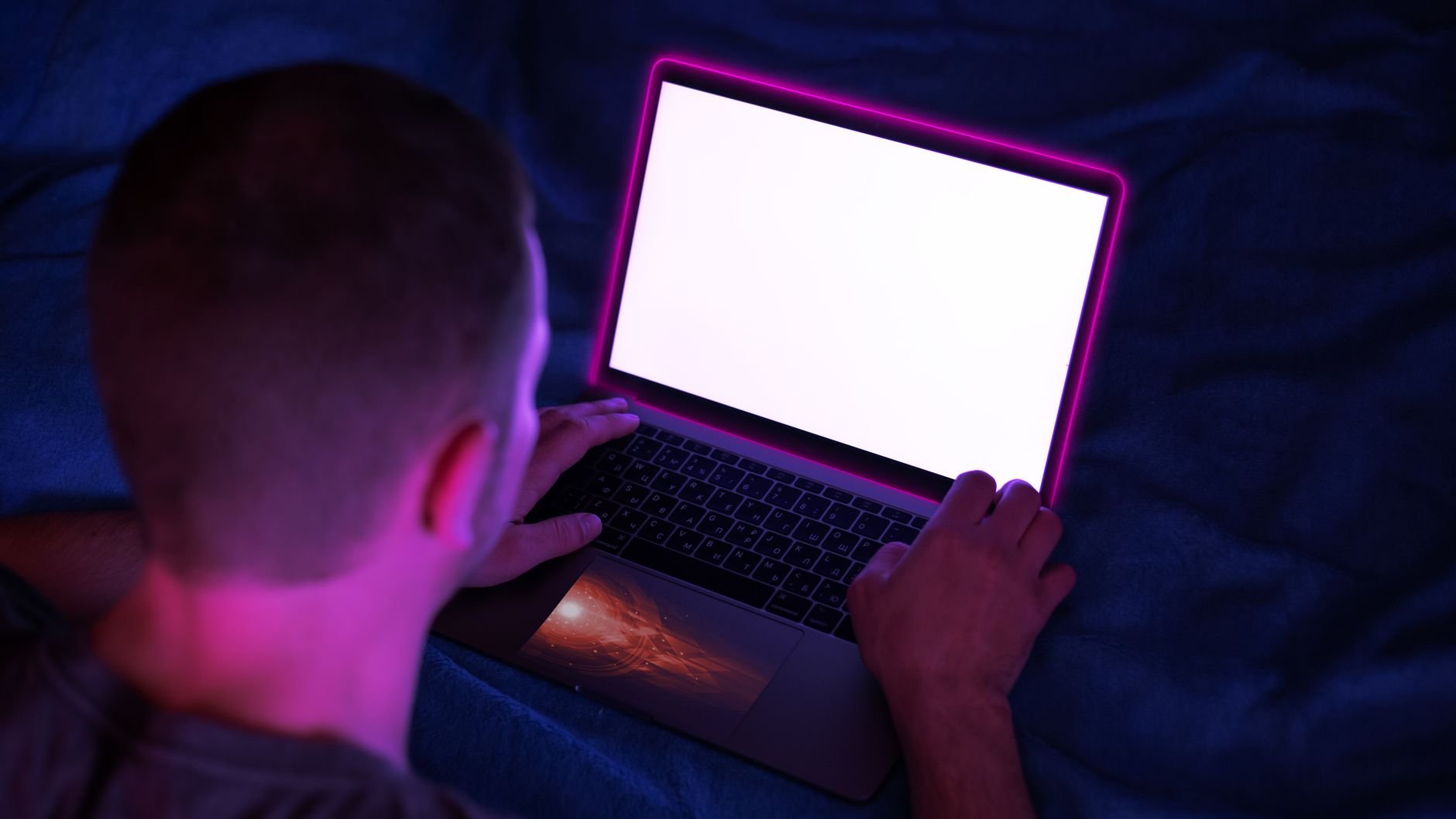 Dark cinematic workspace with glowing laptop screen